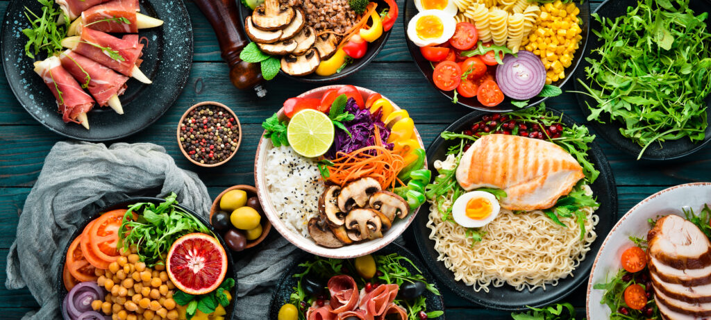 Assortment of healthy food including mushrooms, peppers, rice, fish, chicken, eggs, chick peas, herbs, splayed out top view
Photo by Yaruniv-Studio 