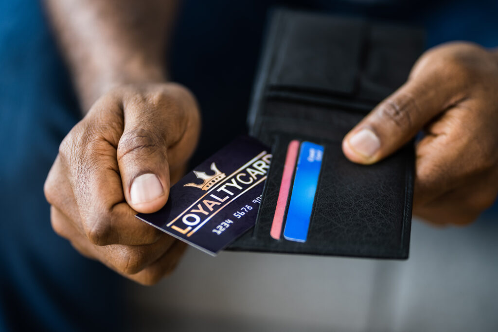 Loyalty Reward Points Program Card In Hand with men's wallet