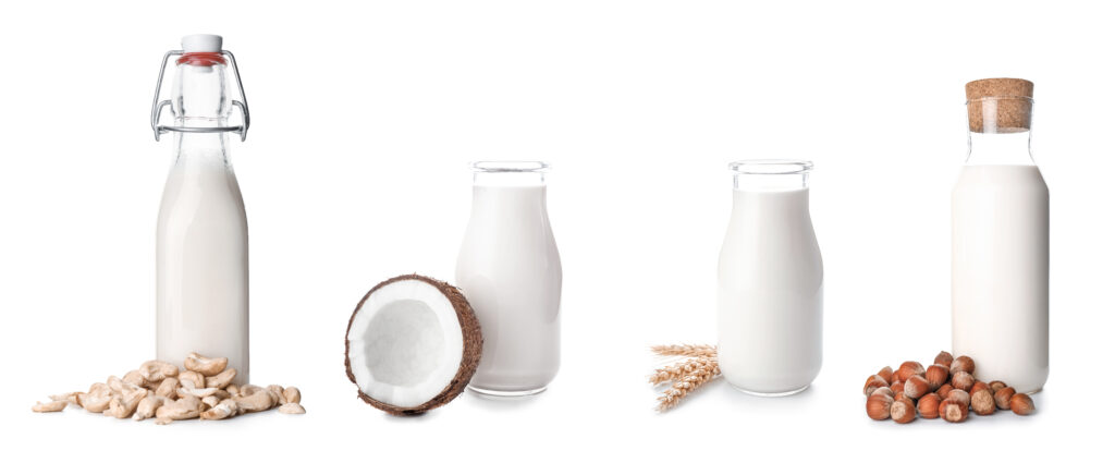 Bottles of different milk on white background